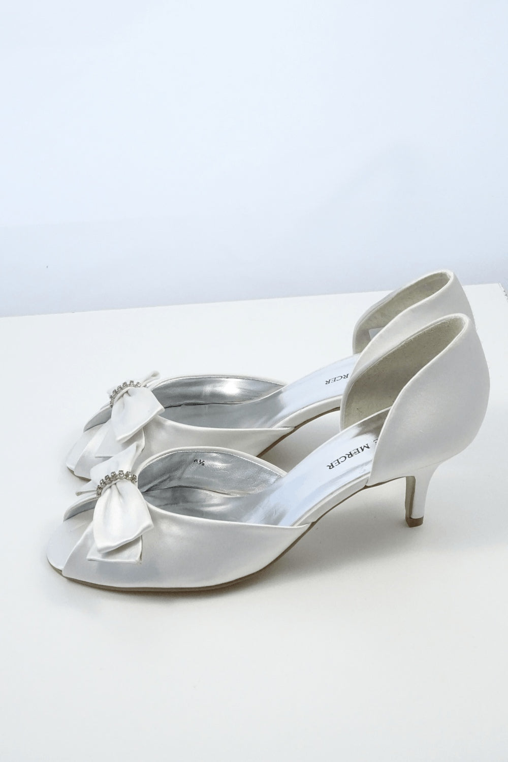 Joanne Mercer white peep toe heels with bow and jewel detailing on toes.