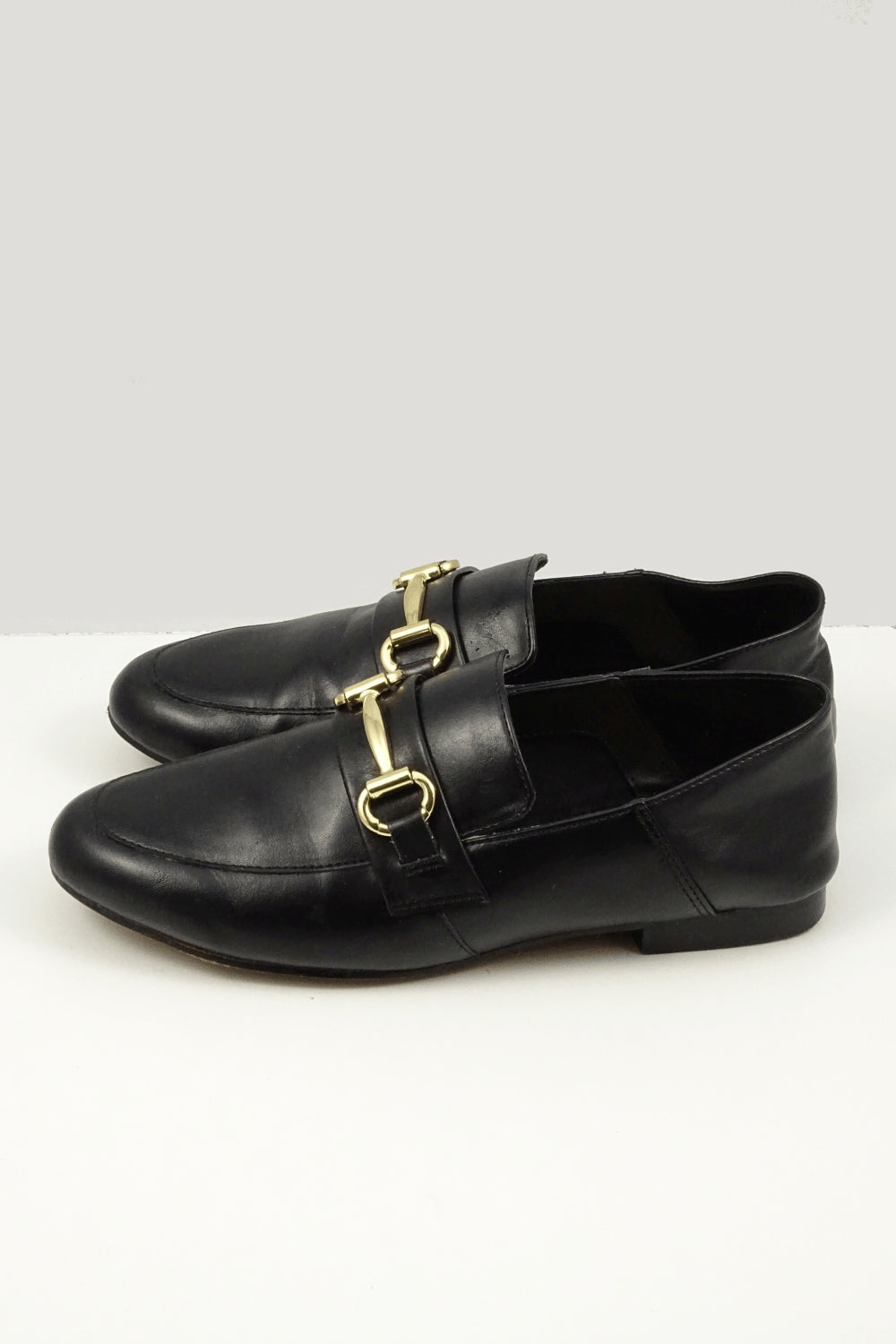 Black loafer with gold buckle detail. Synthetic Upper